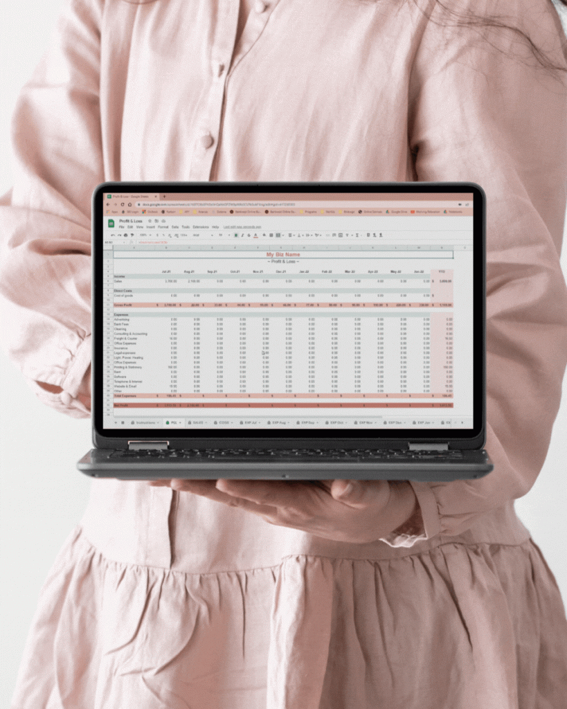 woman in pink linen dress holding laptop displaying scrolling business report on the screen